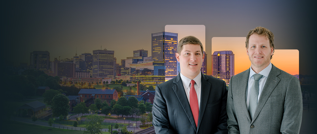 Attorneys Bay Lawrence and Cameron McCormick standing in front of a city skyline.